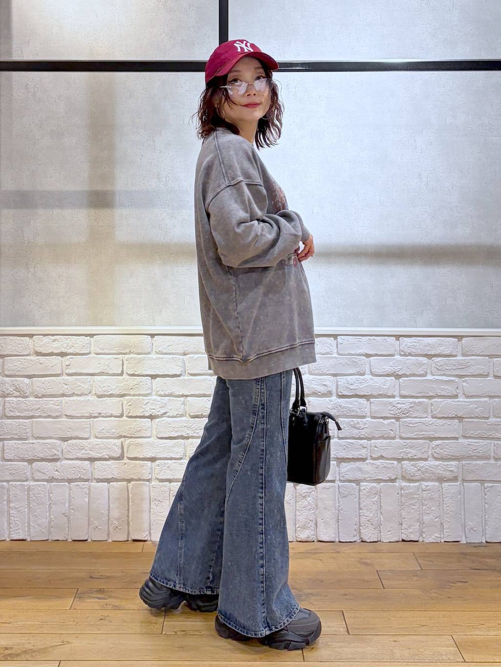 グレー系のスニーカー、ブルー系のデニムパンツ、ブラック系のショルダーバッグを着用したレディースの冬コーディネートの7枚目の写真