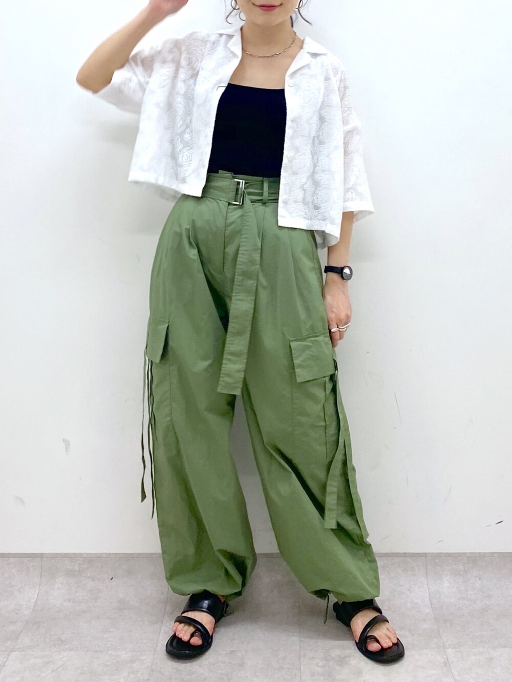 グリーン系のカーゴパンツ、ブラック系のサンダル、ブラック系のトップスを着用したレディースの夏コーディネートの5枚目の写真