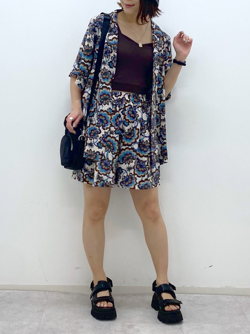 ブラウン系のタンクトップ、ホワイト系のシャツ/ブラウス、ブラック系のショルダーバッグを着用したレディースの春コーディネートの4枚目の写真