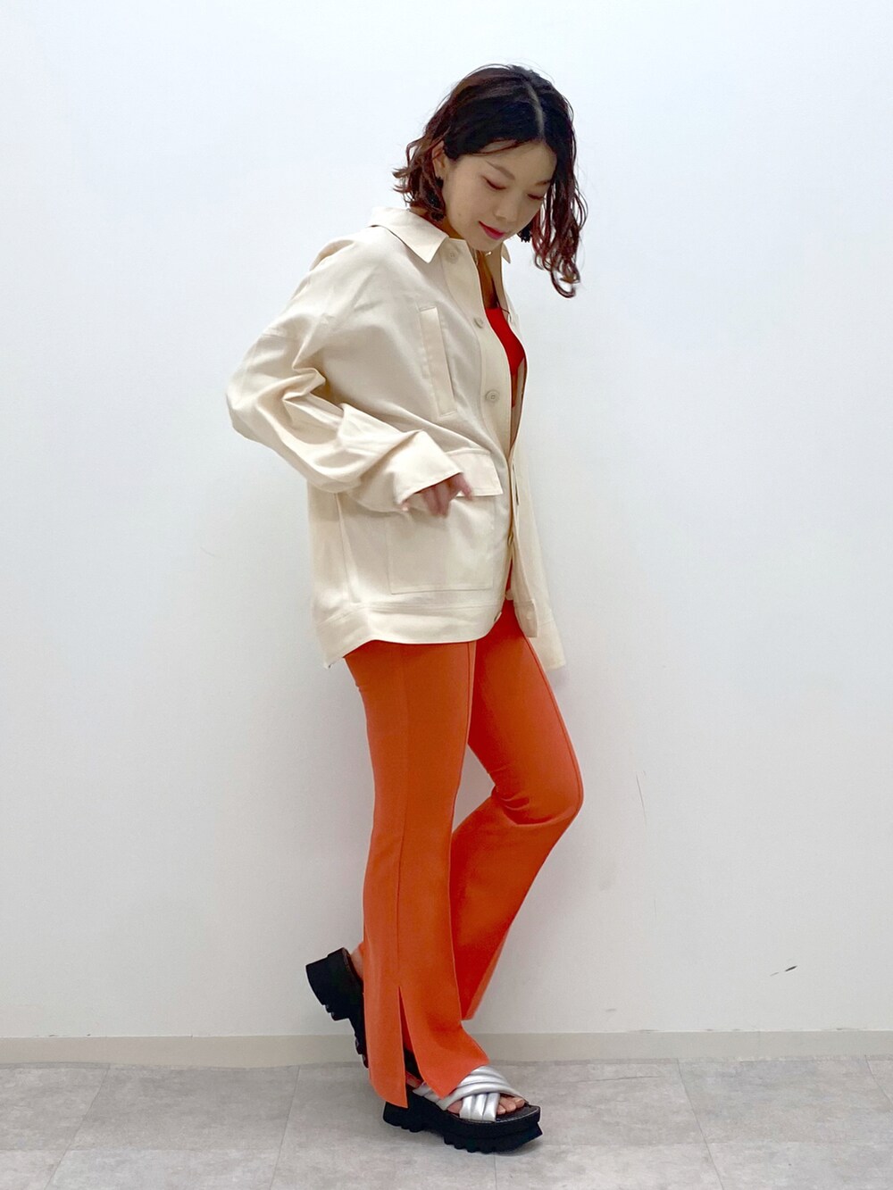 オレンジ系のその他パンツ、シルバー系のサンダル、ベージュ系のミリタリージャケットを着用したレディースの春コーディネートの2枚目の写真