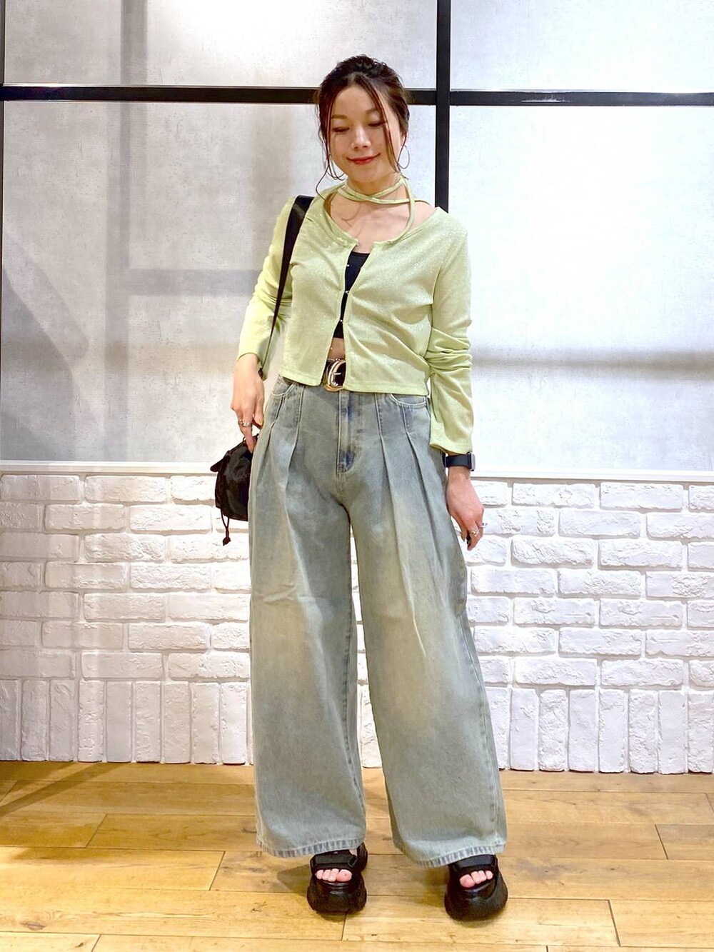 ブルー系のデニムパンツ、ブラック系のサンダル、ブラック系のキャミソールを着用したレディースの春コーディネートの4枚目の写真