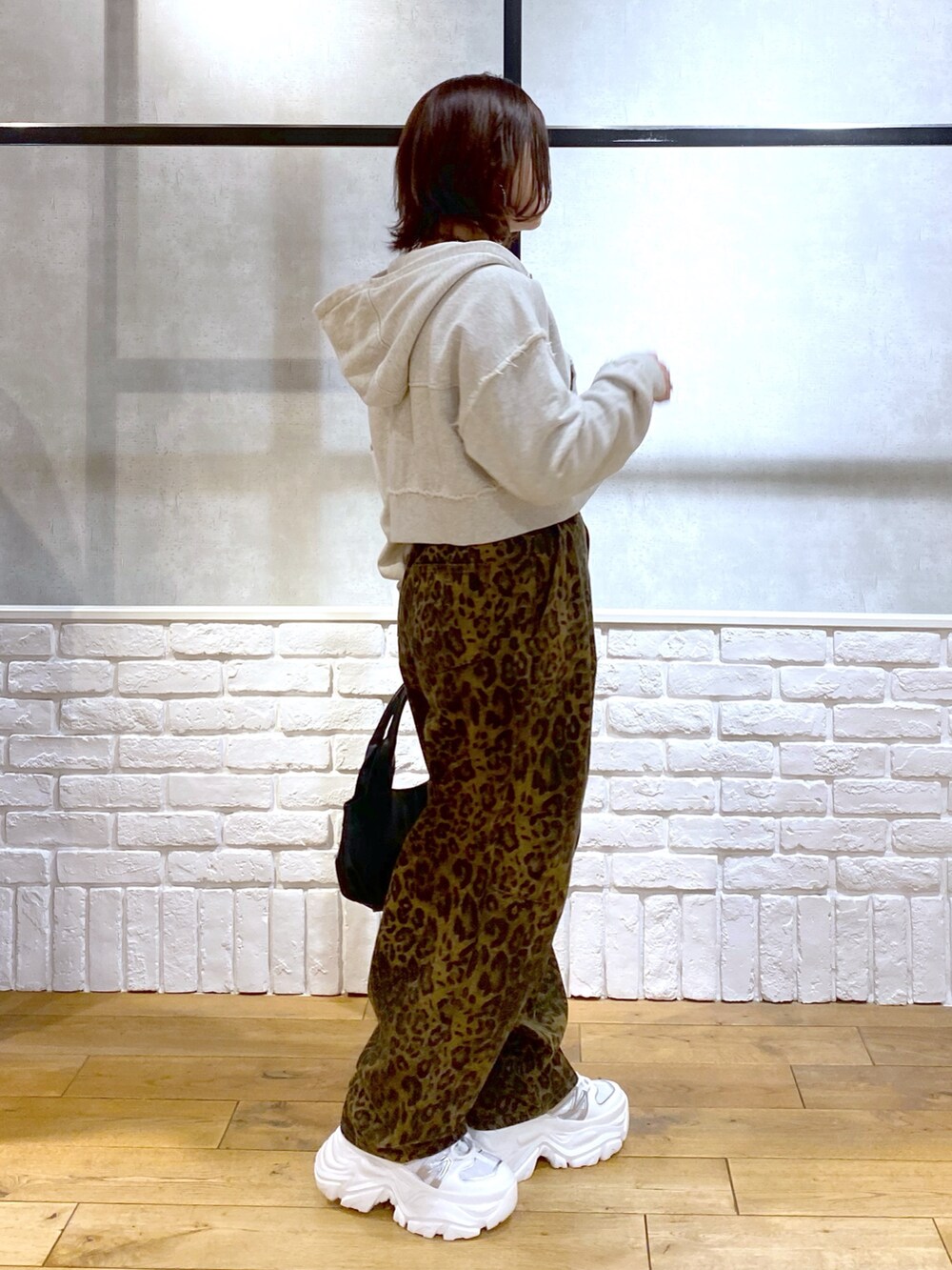 ベージュ系のパーカー、ブラック系のTシャツ/カットソー、その他のデニムパンツを着用したレディースの冬コーディネートの8枚目の写真