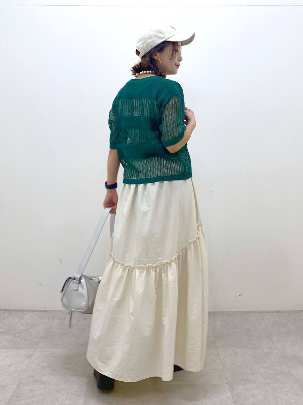 ホワイト系のスカート、グレー系のタンクトップ、シルバー系のショルダーバッグを着用したレディースの夏コーディネートの6枚目の写真