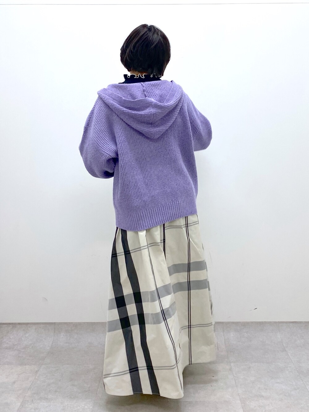 ホワイト系のスカート、パープル系のニット/セーター、ブラック系のニット/セーターを着用したレディースの冬コーディネートの3枚目の写真