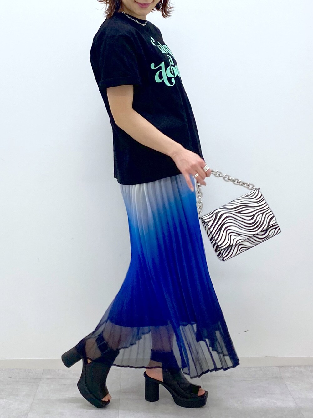 その他のショルダーバッグ、ブラック系のサンダル、ブルー系のスカートを着用したレディースの春コーディネートの4枚目の写真