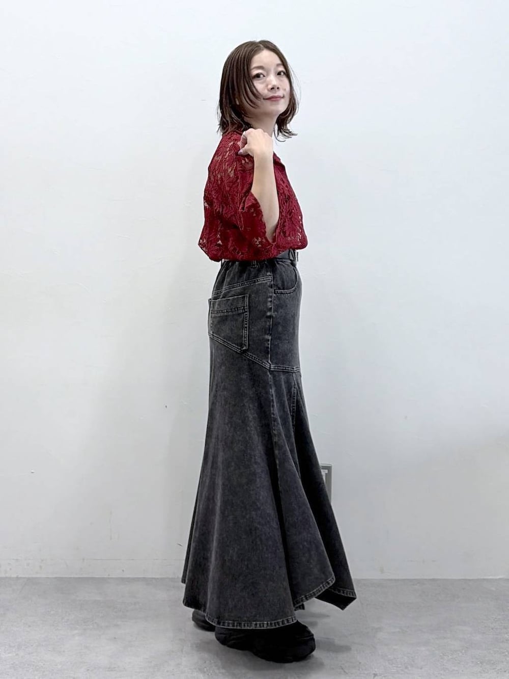 ブラック系のスニーカー、レッド系のシャツ/ブラウス、ブラック系のデニムスカートを着用したレディースの春コーディネートの4枚目の写真