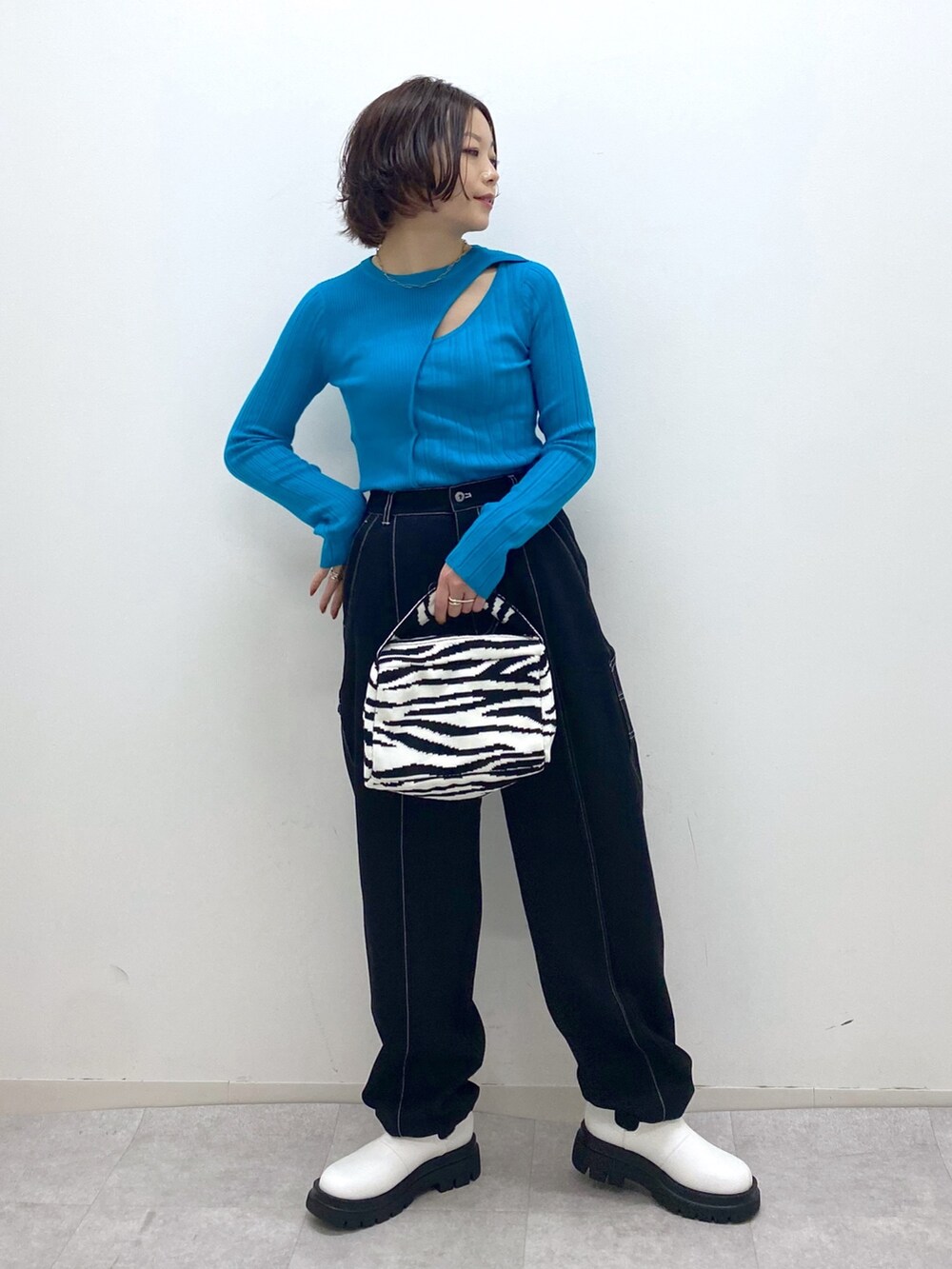 ブラック系のパンツ、ブラック系のバッグ、ホワイト系のシューズを着用したレディースの秋コーディネートの5枚目の写真