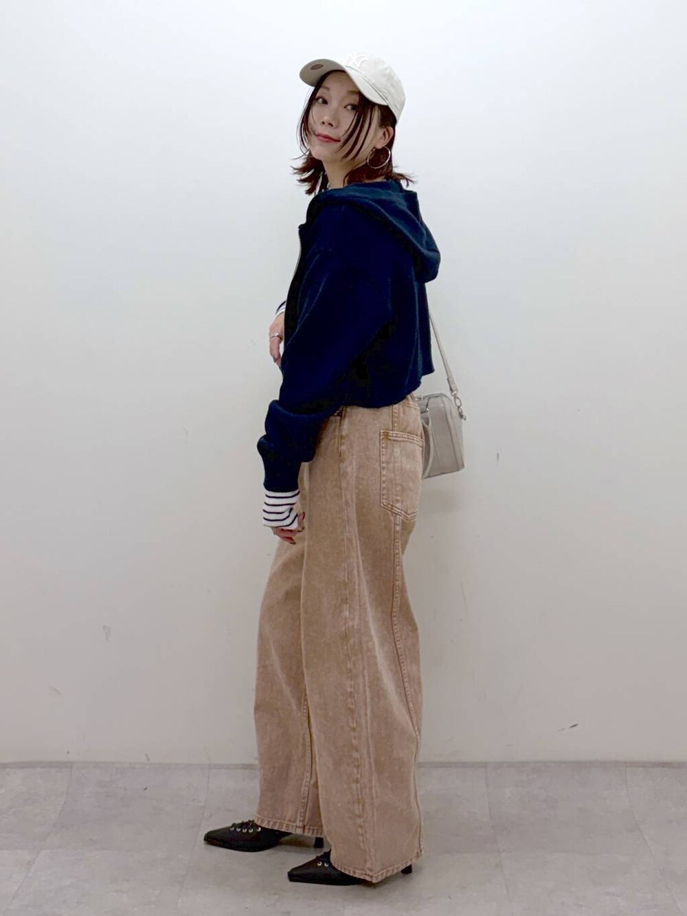 ブラウン系のデニムパンツ、ブラウン系のデニムパンツ、ホワイト系のボストンバッグを着用したレディースの冬コーディネートの7枚目の写真