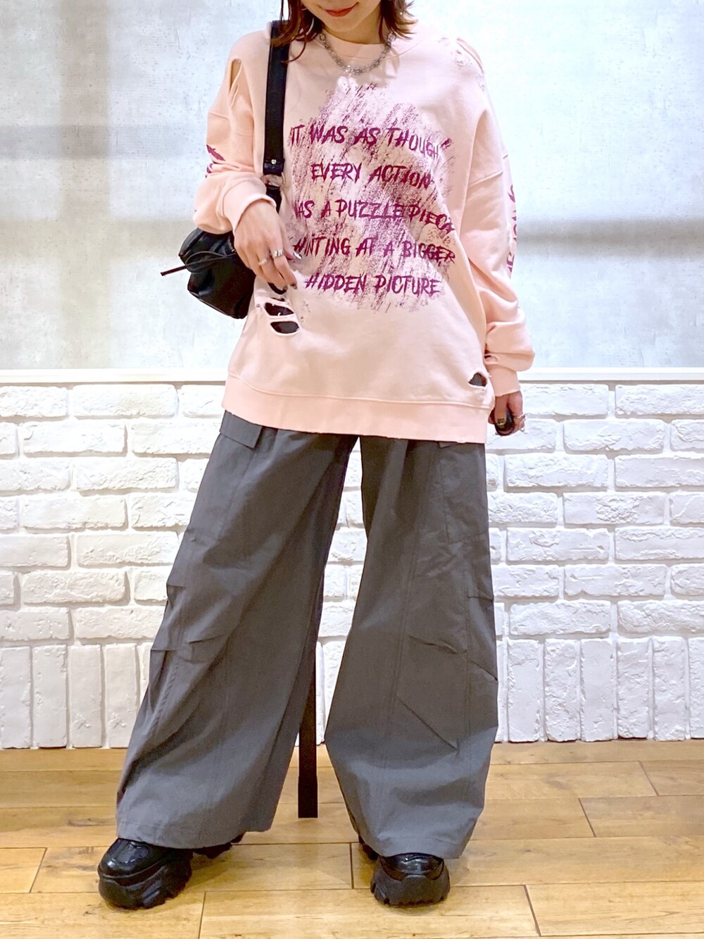 ピンク系のスウェット、グレー系のカーゴパンツ、ブラック系のショルダーバッグを着用したレディースの春コーディネートの3枚目の写真