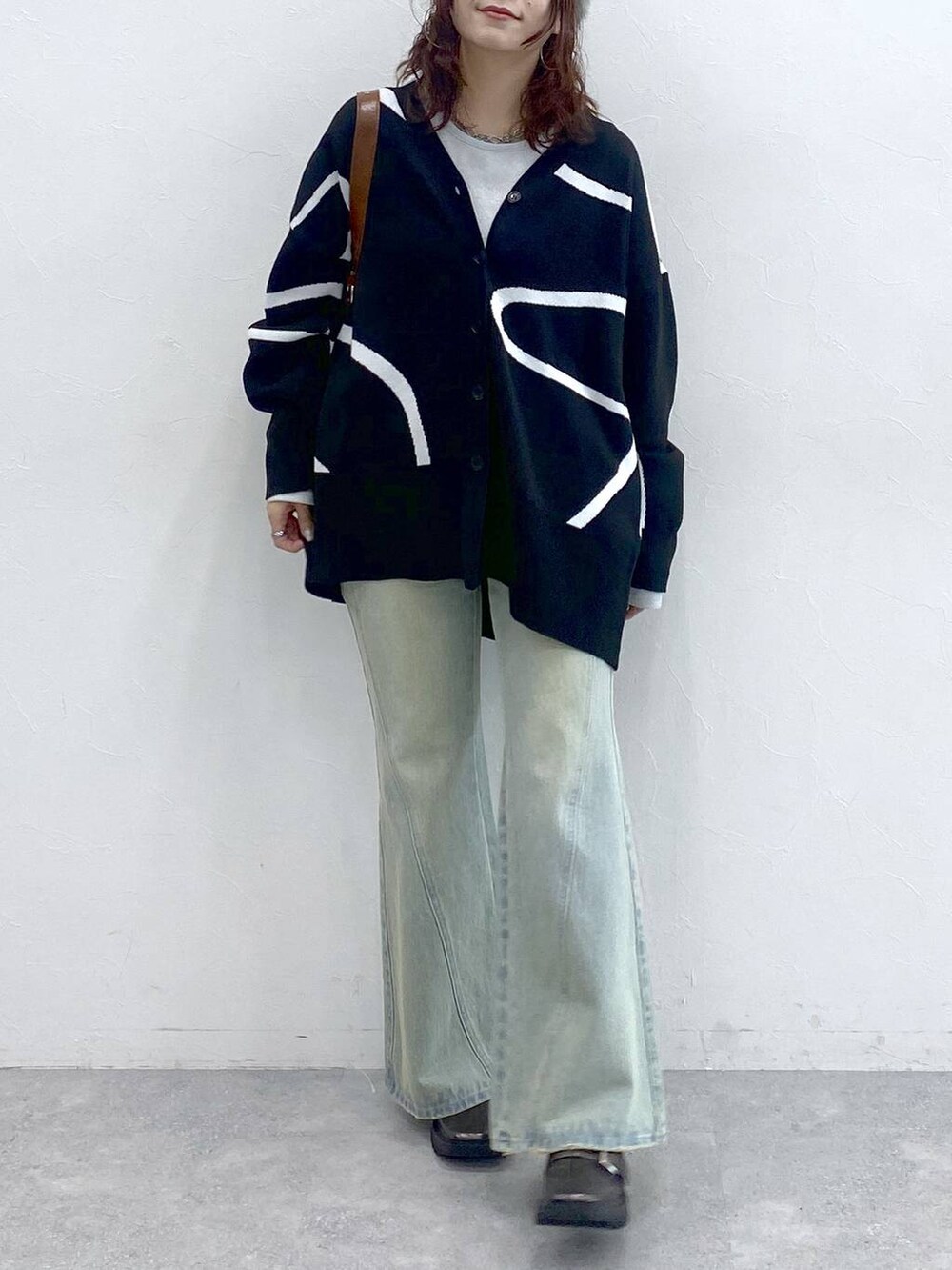 ホワイト系のTシャツ/カットソー、ブルー系のデニムパンツ、ブラック系のカーディガン/ボレロを着用したレディースの秋コーディネートの3枚目の写真