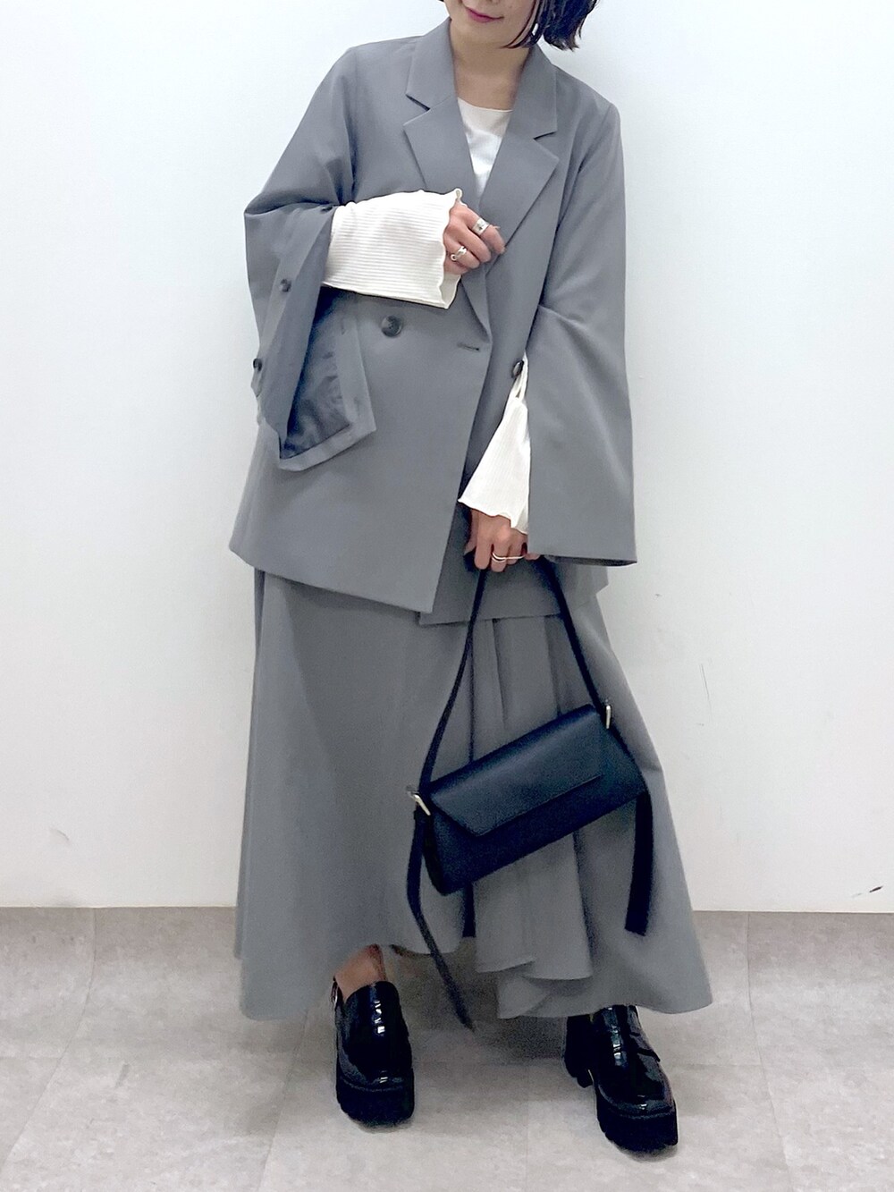 グレー系のジャケット/アウター、グレー系のスカート、ホワイト系のトップスを着用したレディースの春コーディネートの4枚目の写真