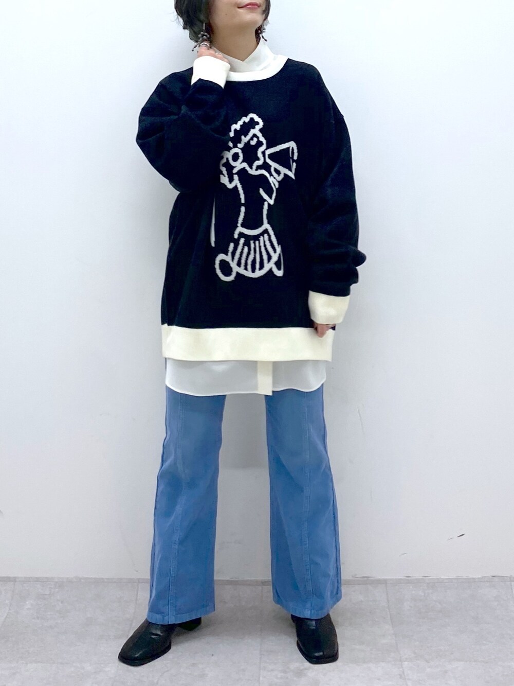 ブラック系のトップス、ホワイト系のトップス、ブルー系のパンツを着用したレディースの秋コーディネートの4枚目の写真