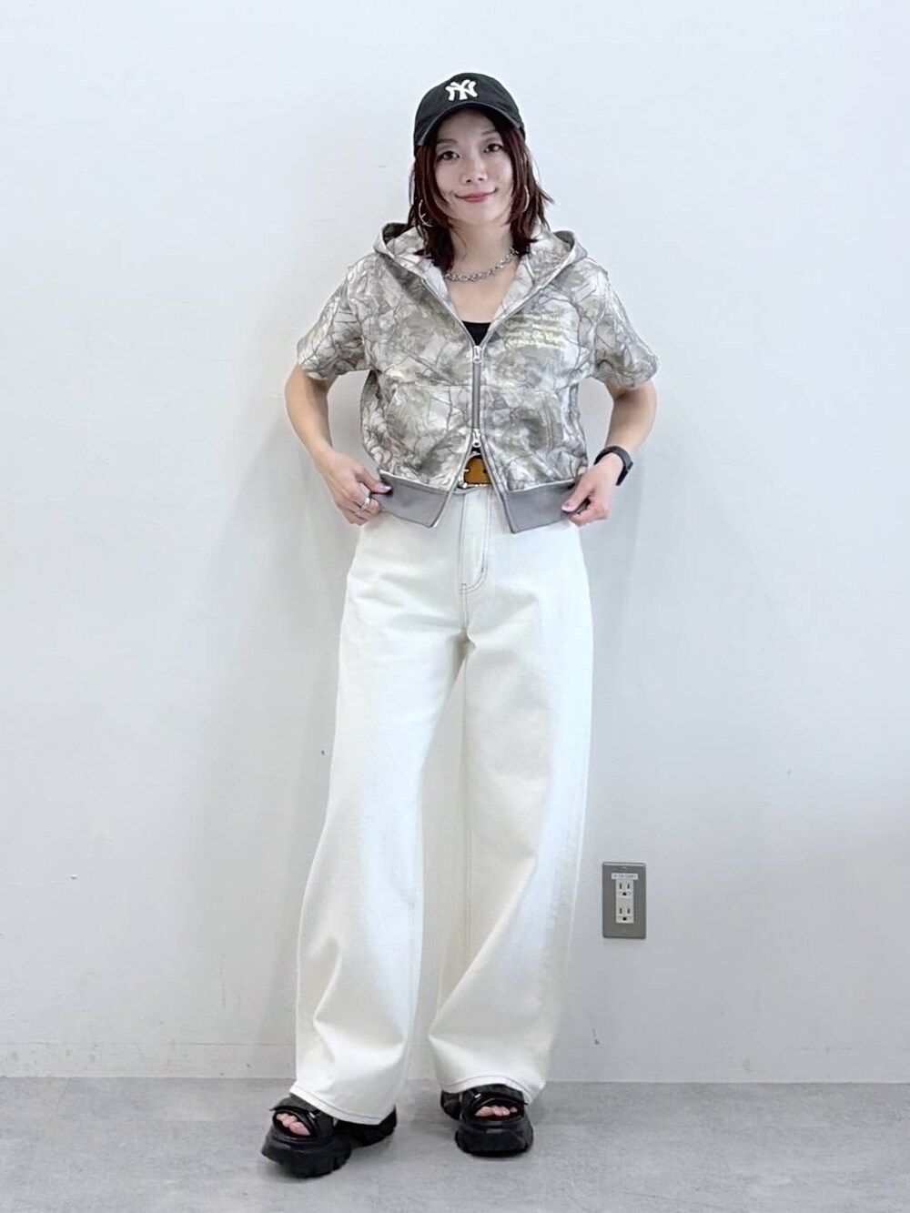 ホワイト系のデニムパンツ、ブラック系のサンダル、その他のパーカーを着用したレディースの春コーディネートの9枚目の写真