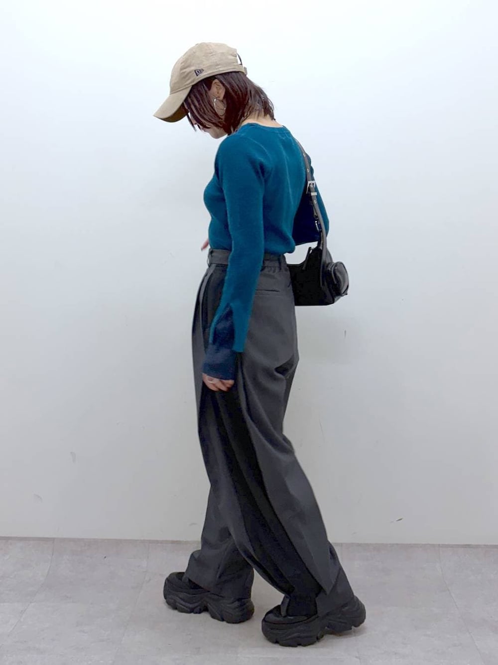 ブラック系のブーツ、グリーン系のニット/セーター、ブラック系のショルダーバッグを着用したレディースの冬コーディネートの7枚目の写真