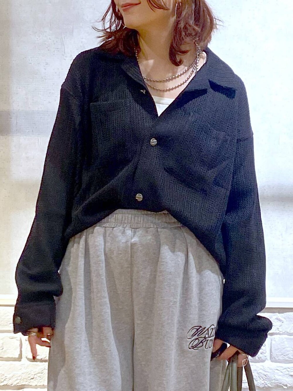 ブラック系のスニーカー、グリーン系のボストンバッグ、グレー系のスウェットパンツを着用したレディースの秋コーディネートの2枚目の写真