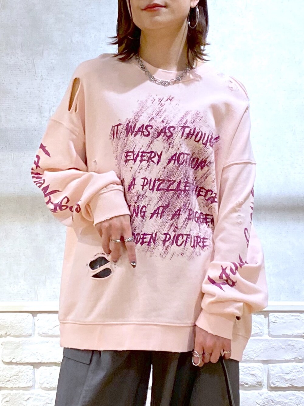 ピンク系のスウェット、グレー系のカーゴパンツ、ブラック系のショルダーバッグを着用したレディースの春コーディネートの2枚目の写真