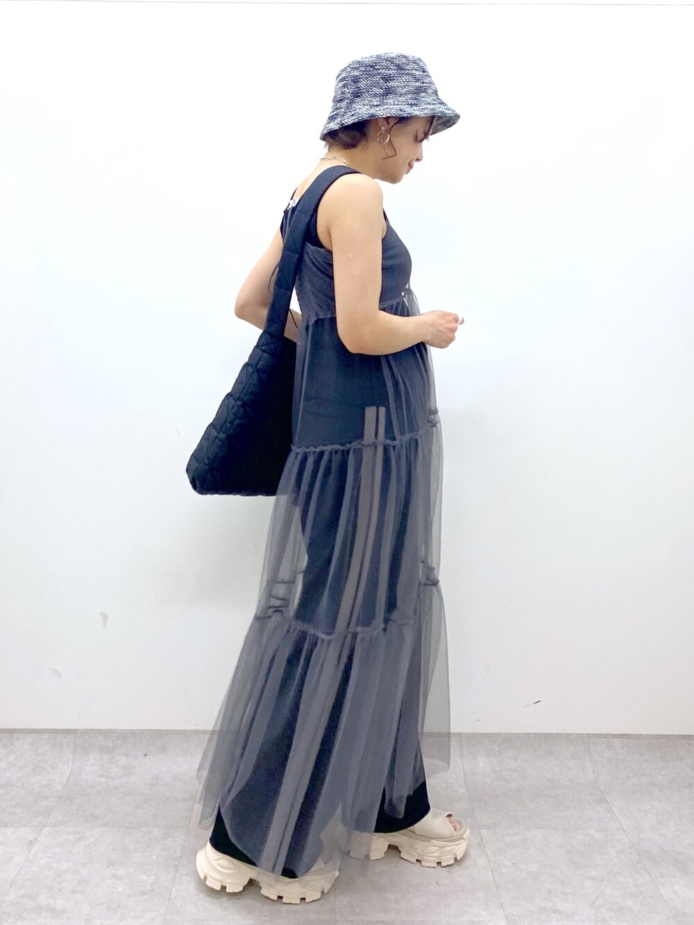 ブラック系のショルダーバッグ、グレー系のワンピース、ブラック系のスウェットパンツを着用したレディースの夏コーディネートの2枚目の写真