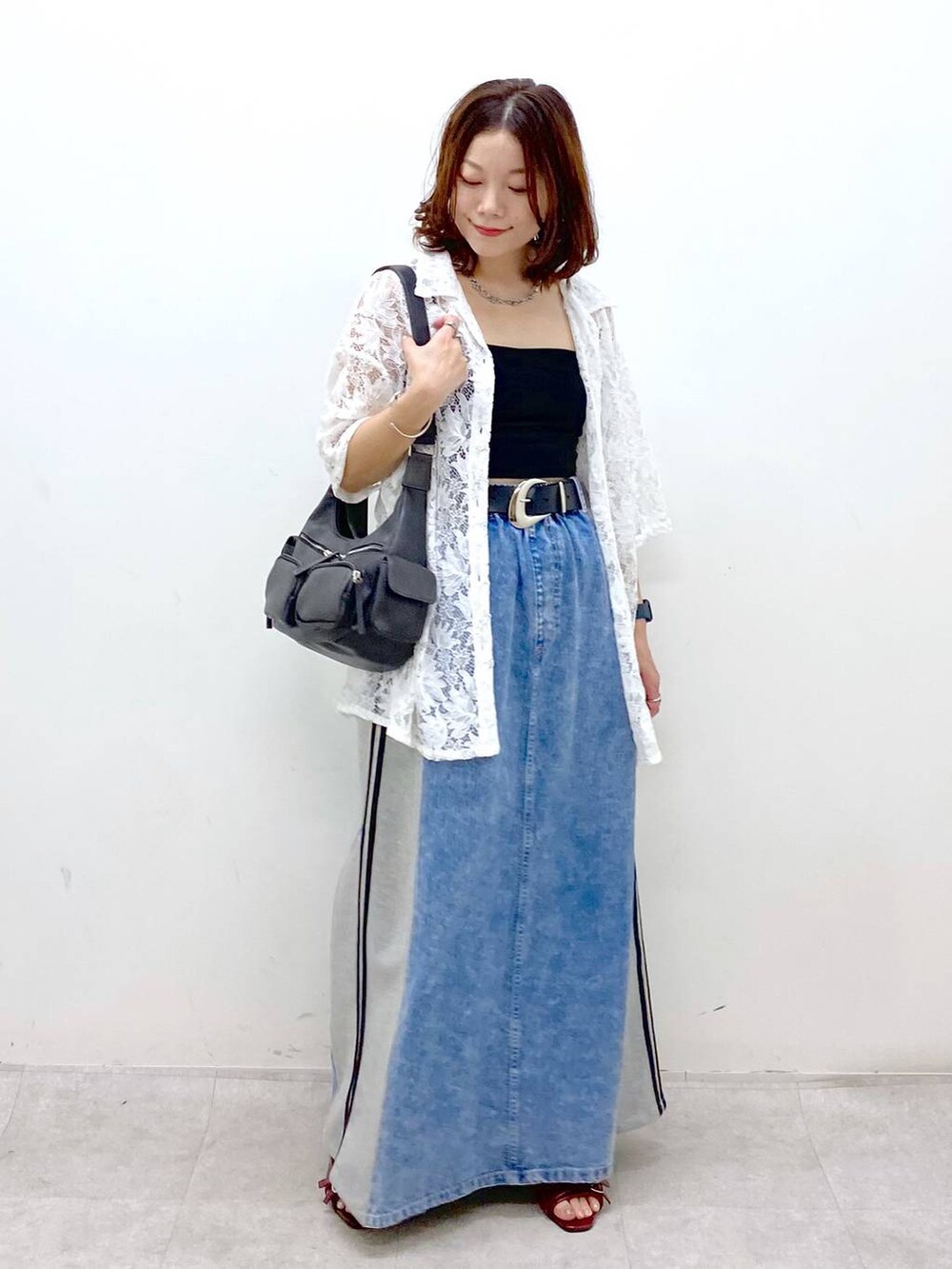 ブラック系のショルダーバッグ、レッド系のサンダル、ブルー系のスカートを着用したレディースの夏コーディネートの4枚目の写真