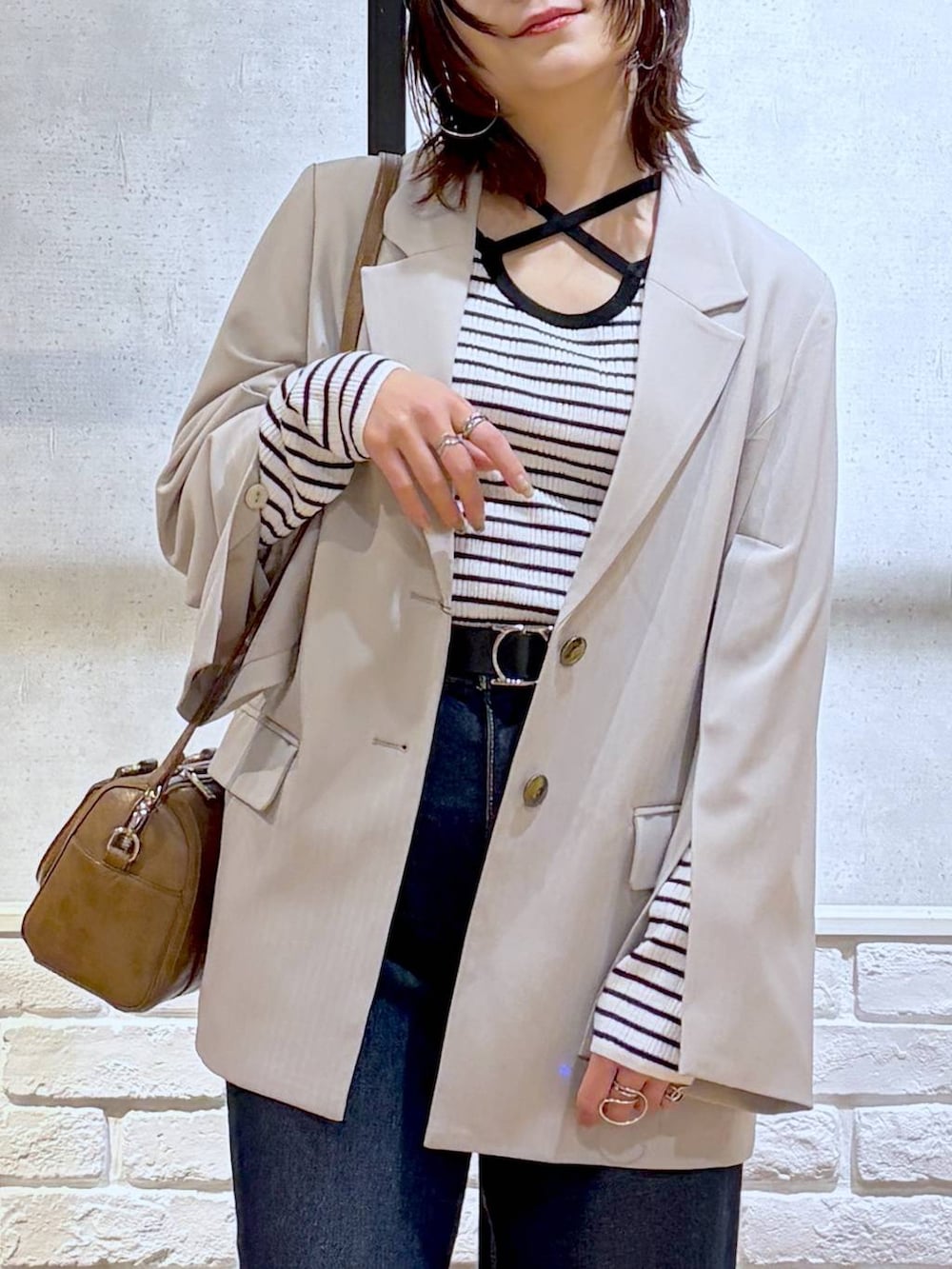 ブラック系のローファー、ブルー系のスラックス、ブラウン系のボストンバッグを着用したレディースの冬コーディネートの2枚目の写真