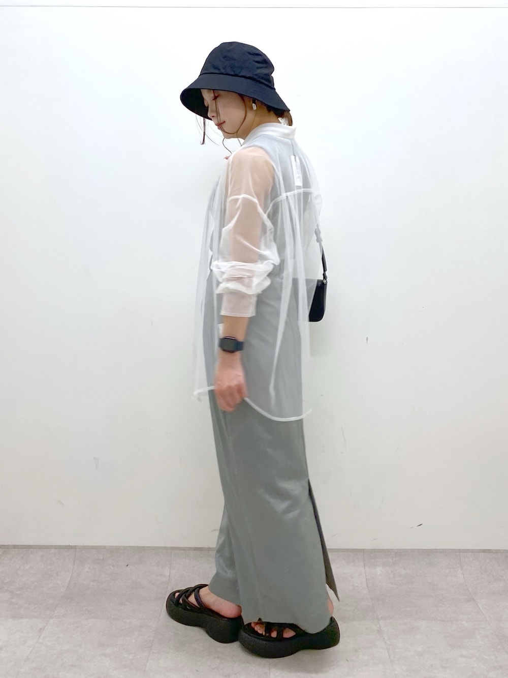 ブルー系のスカート、ブラック系のハンドバッグ、ブラック系のサンダルを着用したレディースの春コーディネートの5枚目の写真