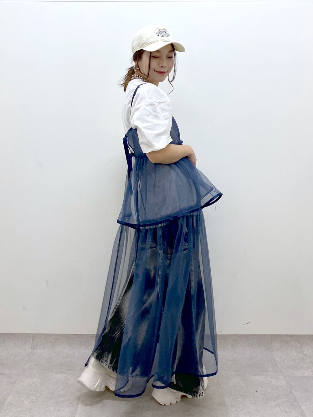 ホワイト系のTシャツ/カットソー、ブルー系のワンピース、ブラック系のデニムパンツを着用したレディースの春コーディネートの8枚目の写真