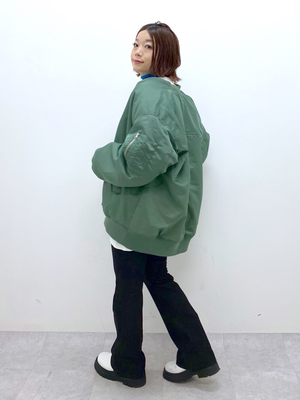 ブラック系のデニムパンツ、ホワイト系のシューズ、ブルー系のTシャツ/カットソーを着用したレディースの秋コーディネートの2枚目の写真