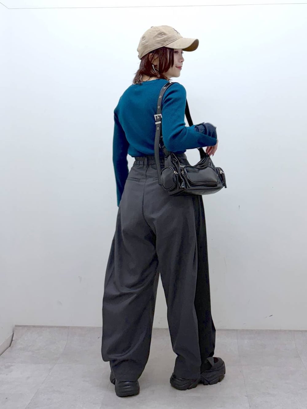 ブラック系のブーツ、グリーン系のニット/セーター、ブラック系のショルダーバッグを着用したレディースの冬コーディネートの6枚目の写真