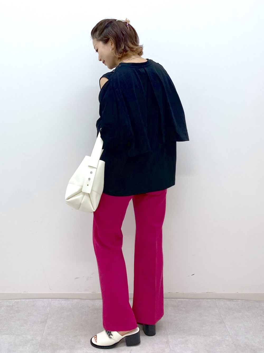 ブラック系のTシャツ/カットソー、ピンク系のスラックス、ホワイト系のバッグを着用したレディースの夏コーディネートの3枚目の写真