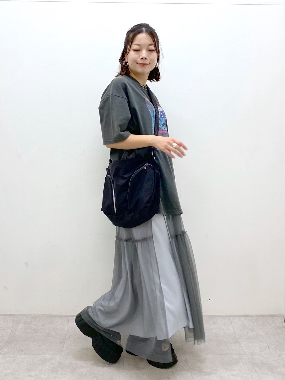 グレー系のTシャツ/カットソー、グレー系のスカート、ブラック系のスニーカーを着用したレディースの夏コーディネートの3枚目の写真