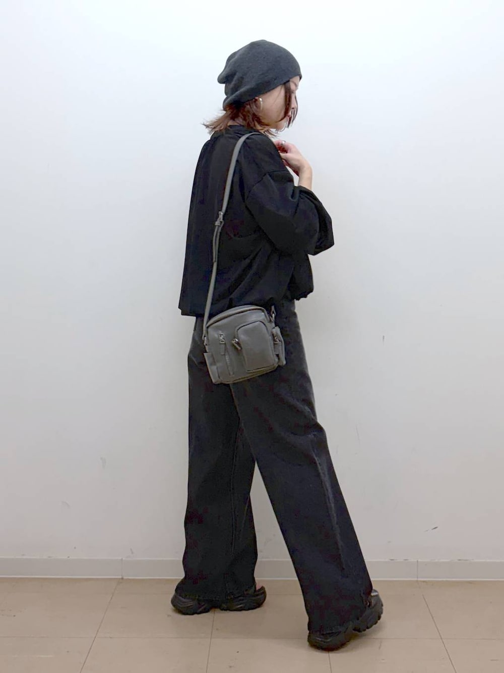 ホワイト系のキャミソール、ブラック系のデニムパンツ、ブラック系のブルゾンを着用したレディースの春コーディネートの6枚目の写真