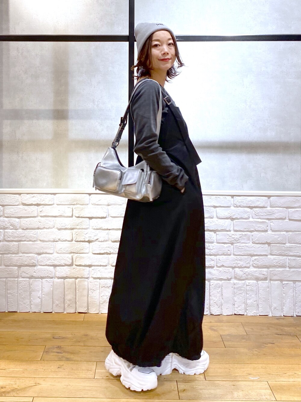 シルバー系のショルダーバッグ、ブラック系のワンピース、グレー系のTシャツ/カットソーを着用したレディースの冬コーディネートの4枚目の写真