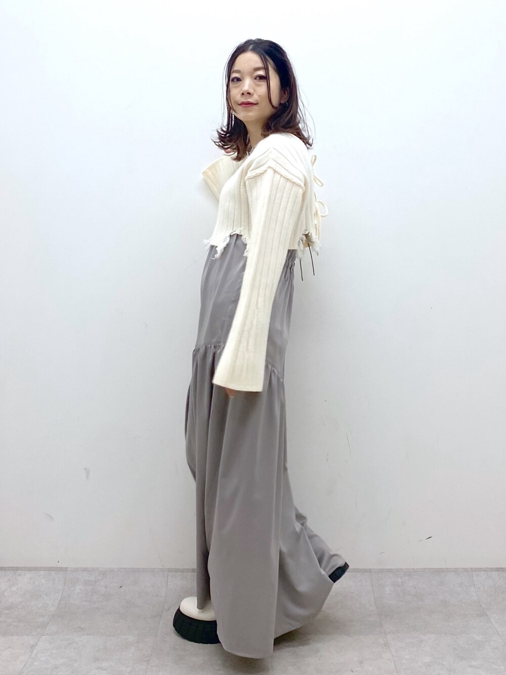 ホワイト系のワンピース、ピンク系のショルダーバッグ、ホワイト系のブーツを着用したレディースの冬コーディネートの5枚目の写真