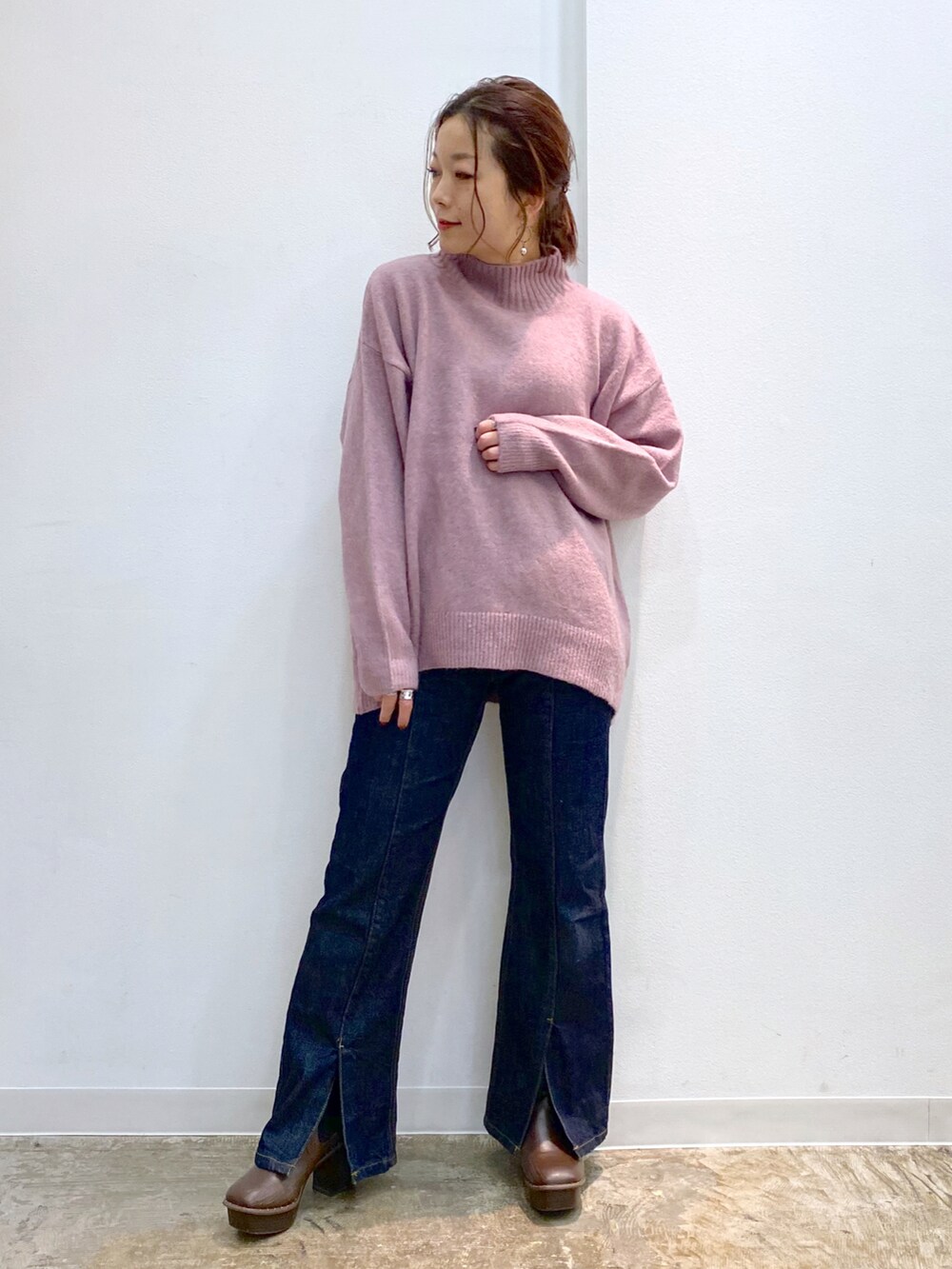 ピンク系のニット/セーター、ブルー系のデニムパンツ、ブラウン系のブーツを着用したレディースの秋コーディネートの4枚目の写真