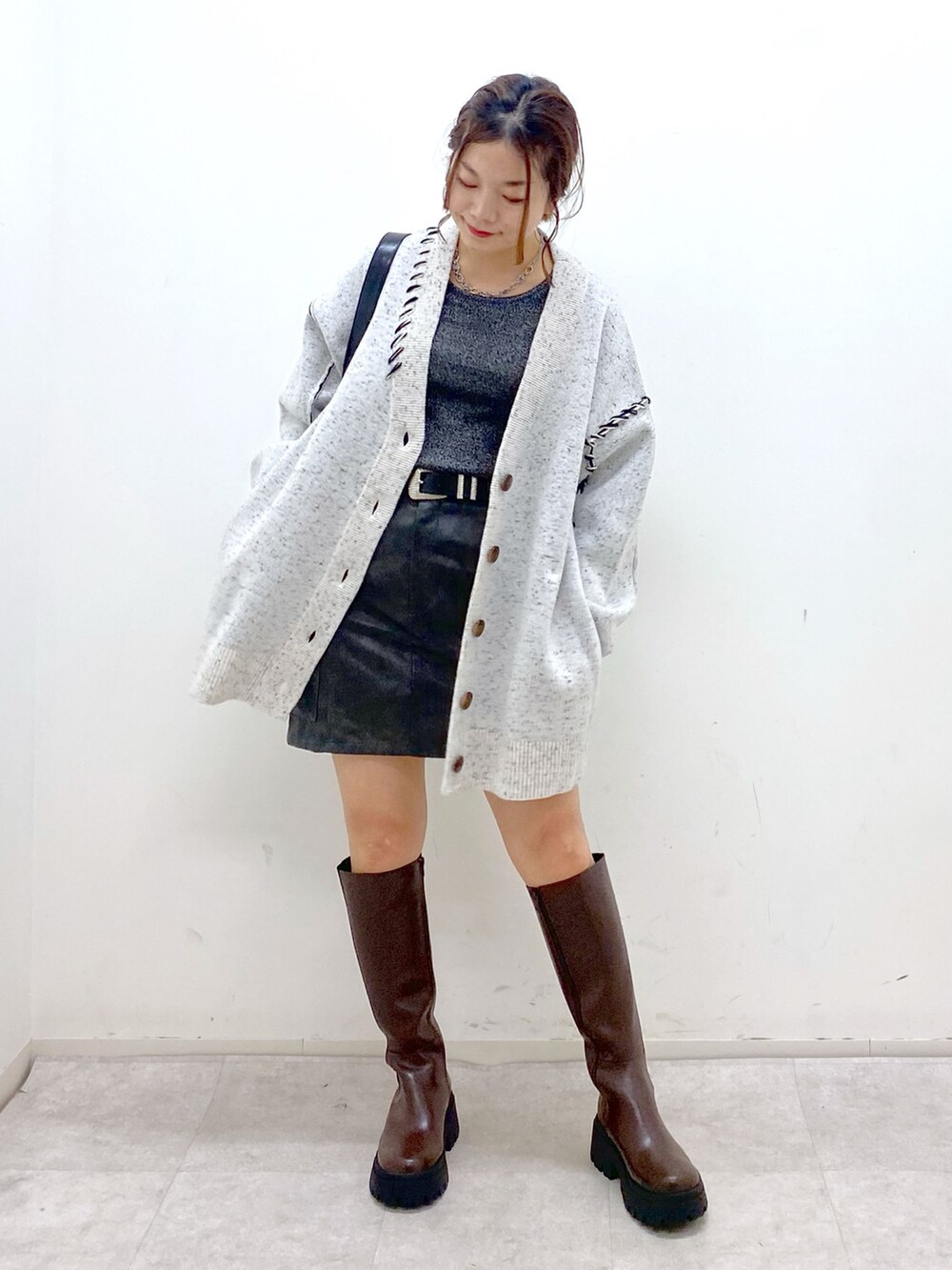 ホワイト系のニット/セーター、シルバー系のTシャツ/カットソー、ブラック系のスカートを着用したレディースの秋コーディネートの8枚目の写真