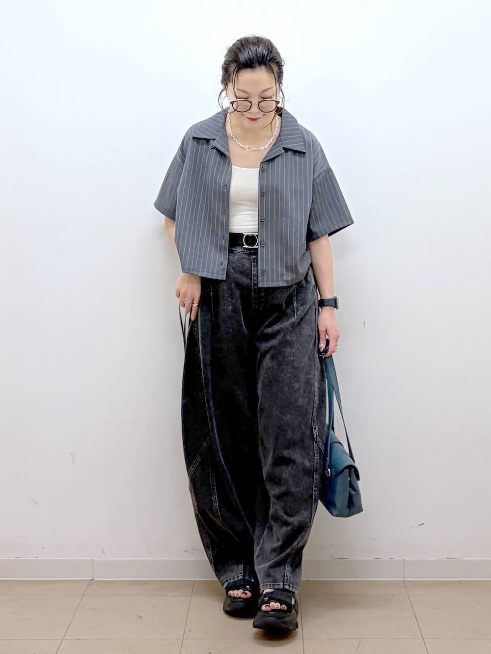 ブラック系のデニムパンツ、ブラック系のサンダル、グレー系のシャツ/ブラウスを着用したレディースの夏コーディネートの9枚目の写真
