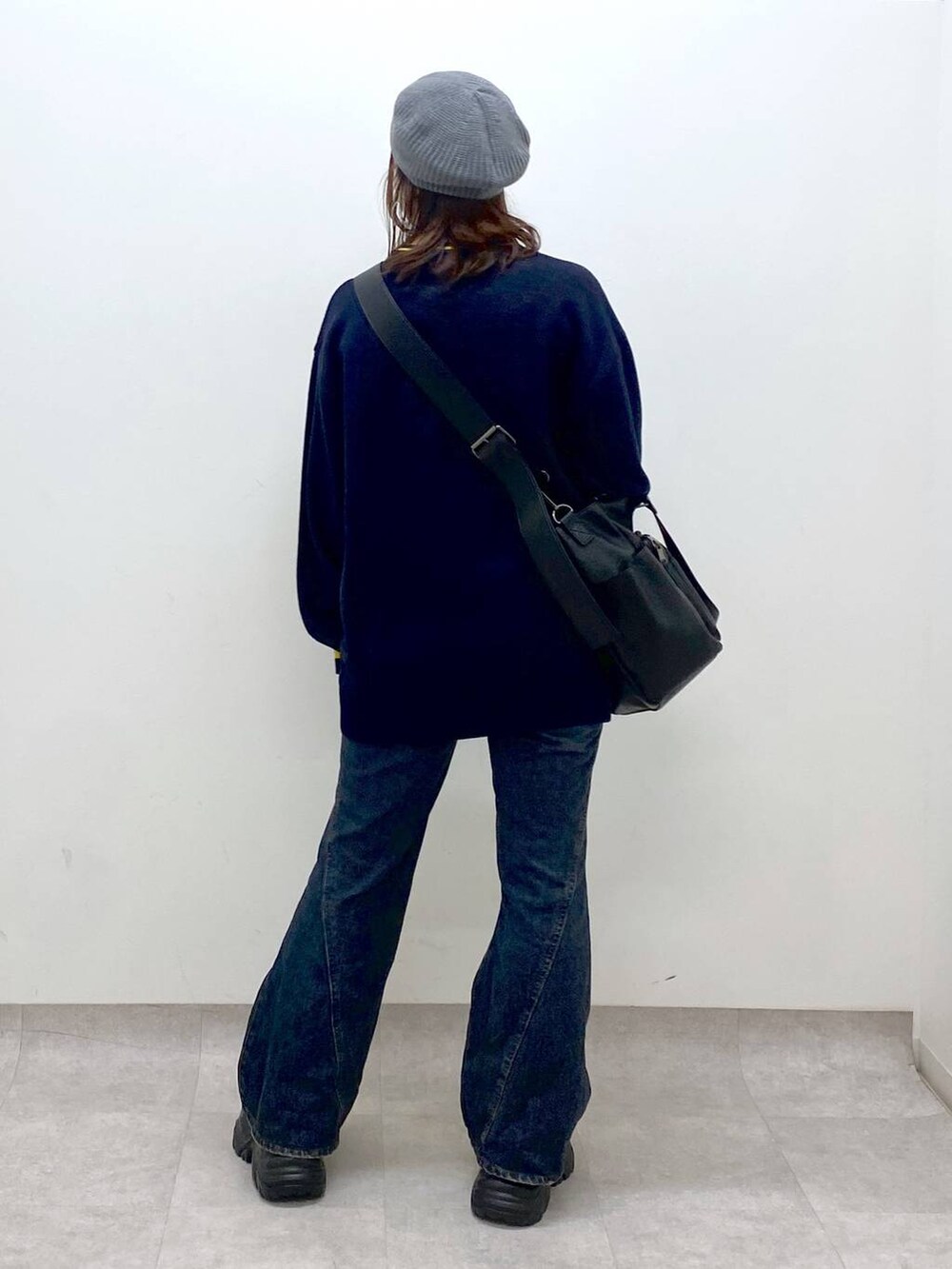 ブラウン系のブーツ、ブルー系のデニムパンツ、ブラック系のボストンバッグを着用したレディースの秋コーディネートの6枚目の写真