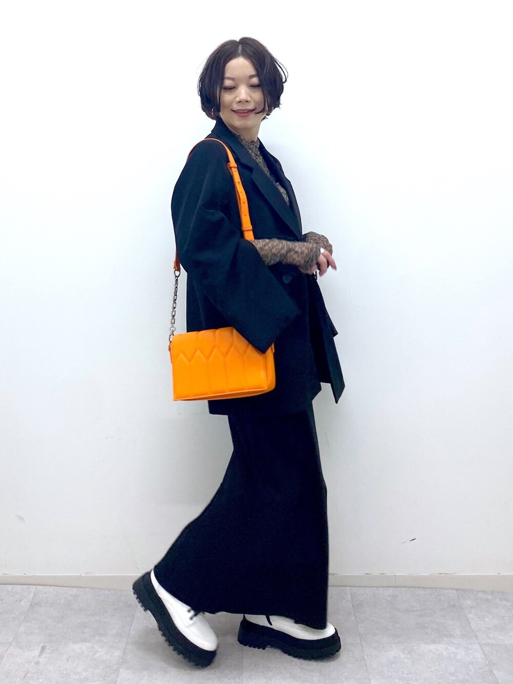 ブラック系のスカート、ホワイト系のブーツ、ブラック系のジャケット/アウターを着用したレディースの秋コーディネートの3枚目の写真