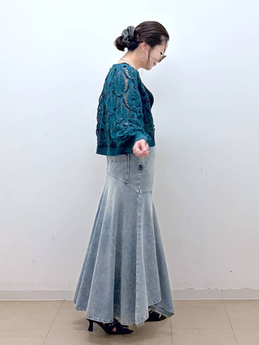 グリーン系のカーディガン/ボレロ、ブルー系のデニムスカート、ブラック系のタンクトップを着用したレディースの夏コーディネートの5枚目の写真