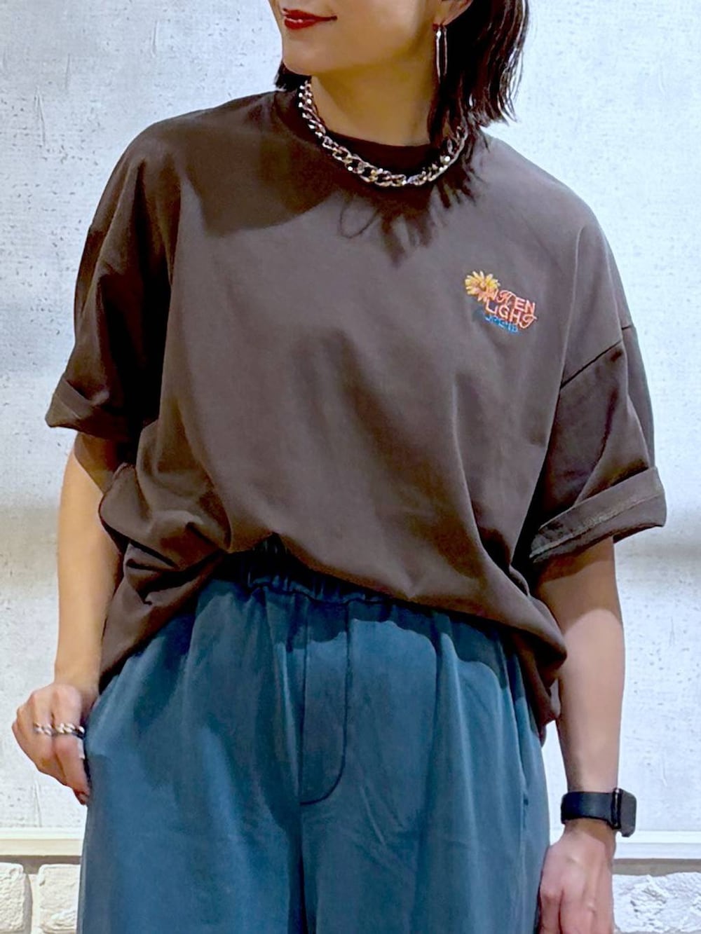 シルバー系のショルダーバッグ、ブラック系のサンダル、ブラウン系のTシャツ/カットソーを着用したレディースの春コーディネートの2枚目の写真