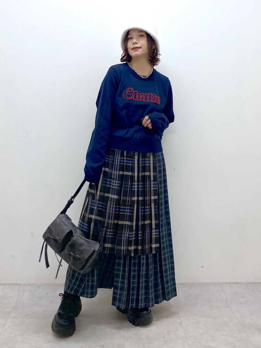 ブルー系のニット/セーター、ブルー系のスカート、ブラック系のショルダーバッグを着用したレディースの秋コーディネートの9枚目の写真