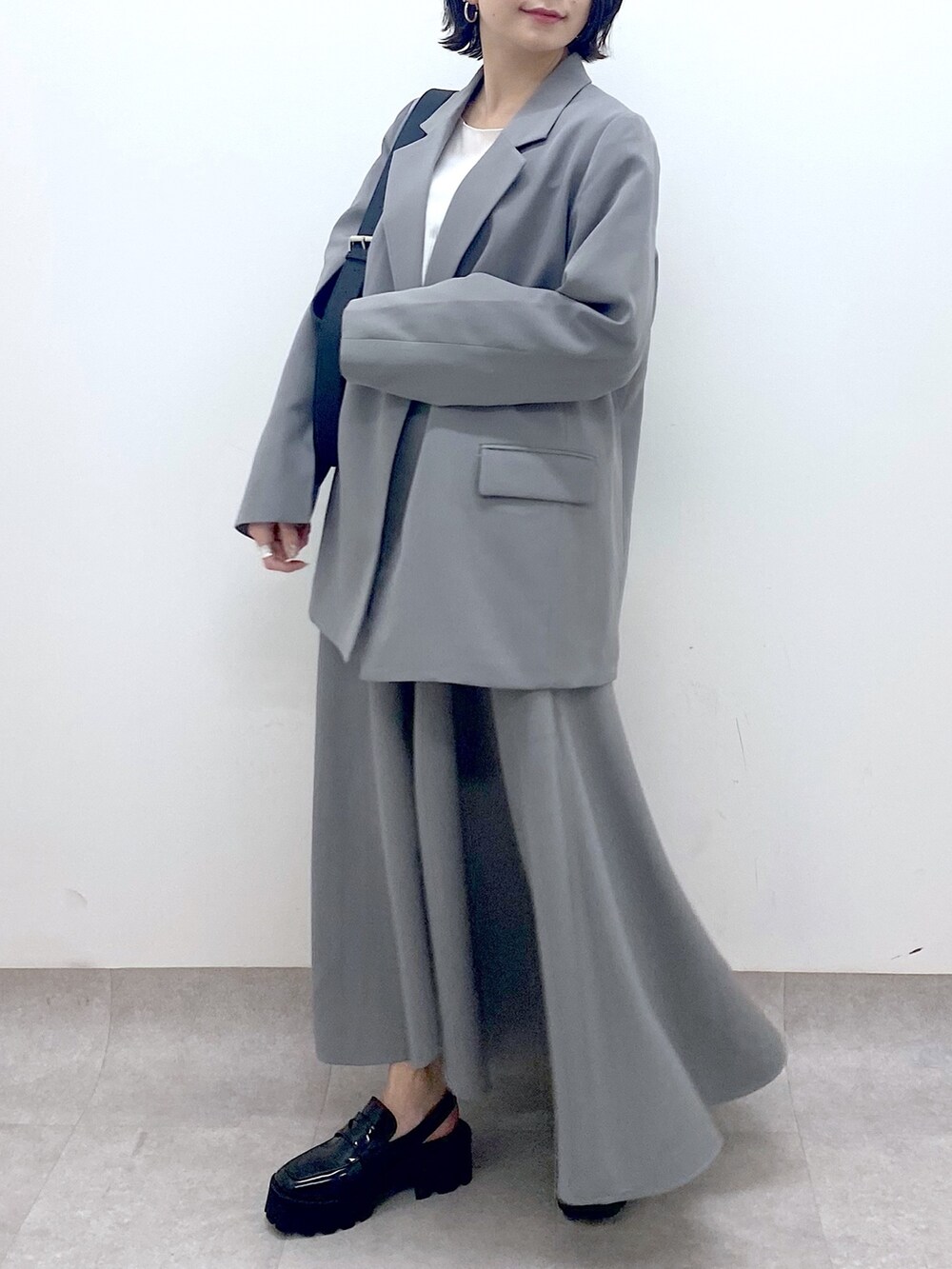 グレー系のジャケット/アウター、グレー系のスカート、ホワイト系のトップスを着用したレディースの春コーディネートの5枚目の写真