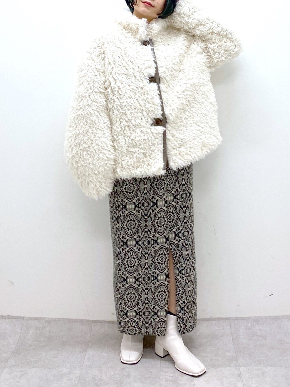 ブラック系のスカート、ブルー系のトップス、ホワイト系のシューズを着用したレディースの秋コーディネートの5枚目の写真