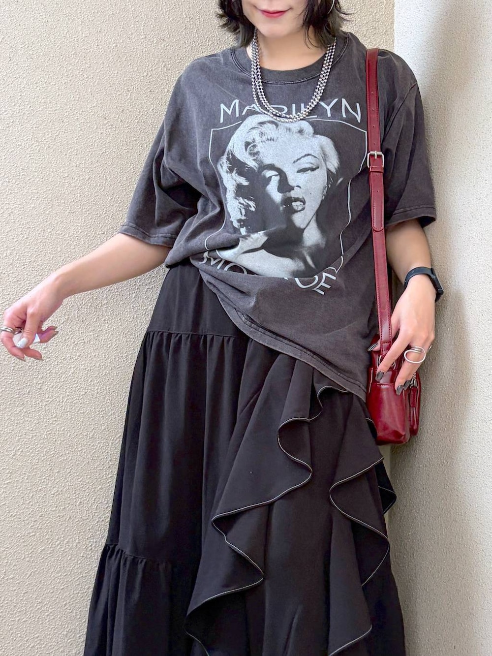 グレー系のTシャツ/カットソー、ブラック系のスカート、レッド系のショルダーバッグを着用したレディースの夏コーディネートの2枚目の写真
