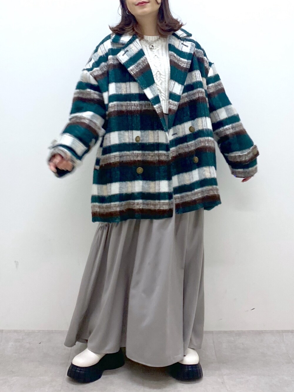 グリーン系のその他アウター、ホワイト系のニット/セーター、ホワイト系のワンピースを着用したレディースの冬コーディネートの7枚目の写真