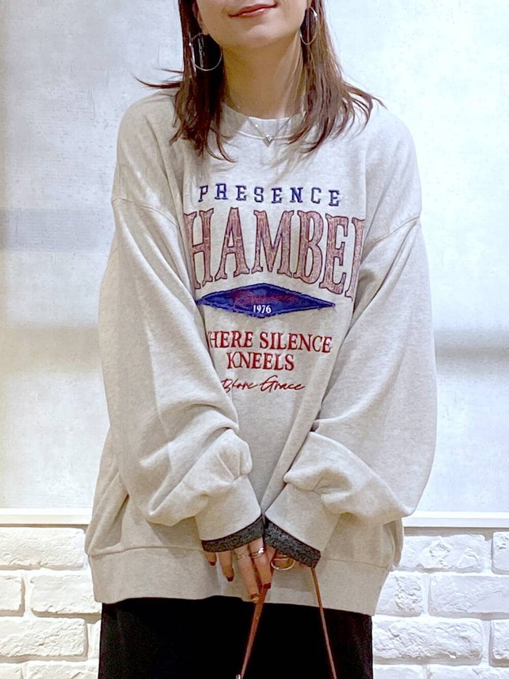 ブラウン系のブーツ、シルバー系のTシャツ/カットソー、ベージュ系のスウェットを着用したレディースの冬コーディネートの2枚目の写真