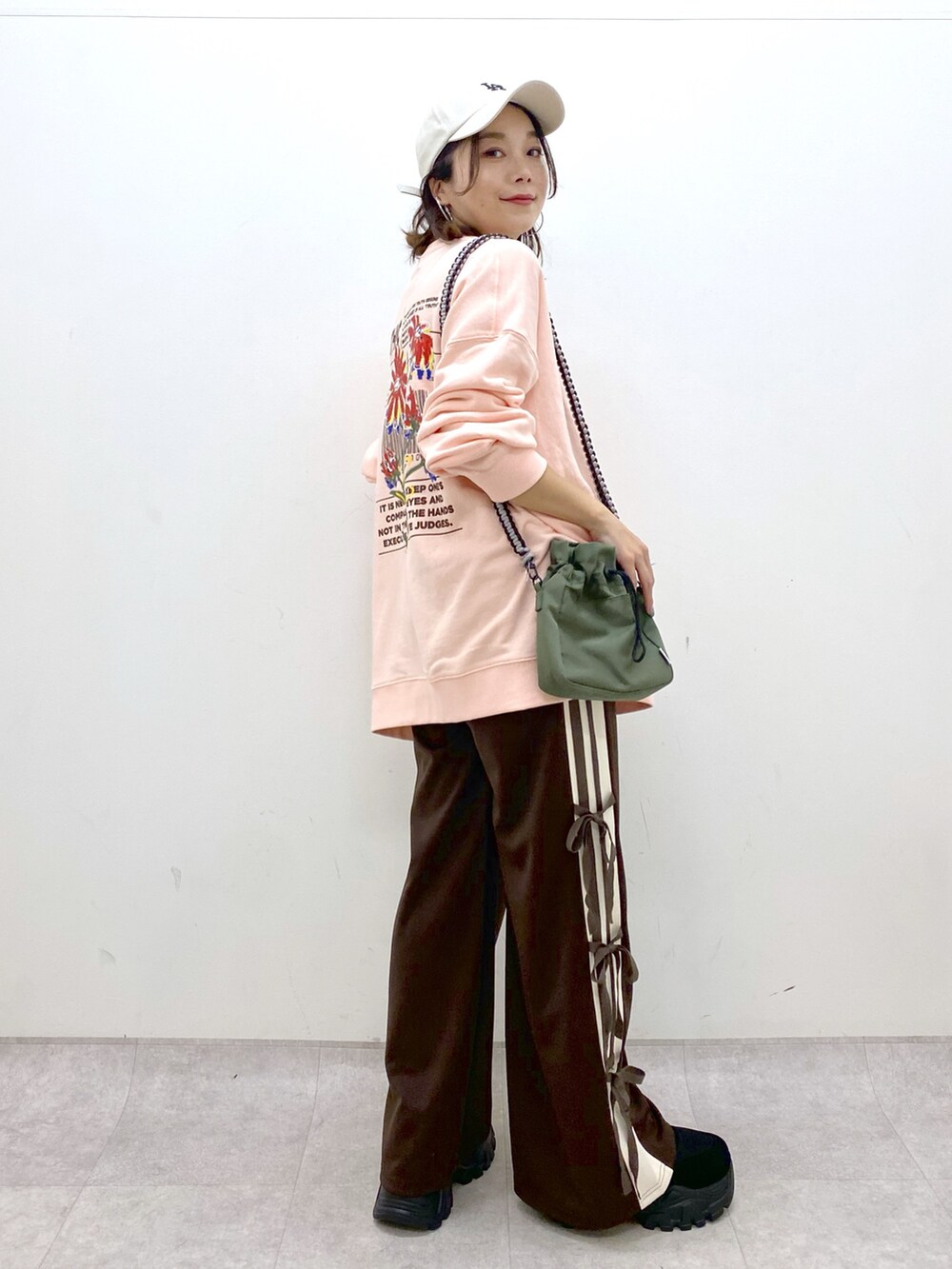 ピンク系のスウェット、グリーン系のショルダーバッグ、ブラウン系のその他パンツを着用したレディースの夏コーディネートの8枚目の写真