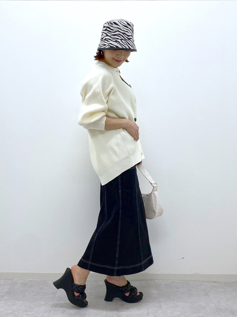 ホワイト系のカーディガン/ボレロ、グリーン系のタンクトップ、ホワイト系のショルダーバッグを着用したレディースの春コーディネートの5枚目の写真