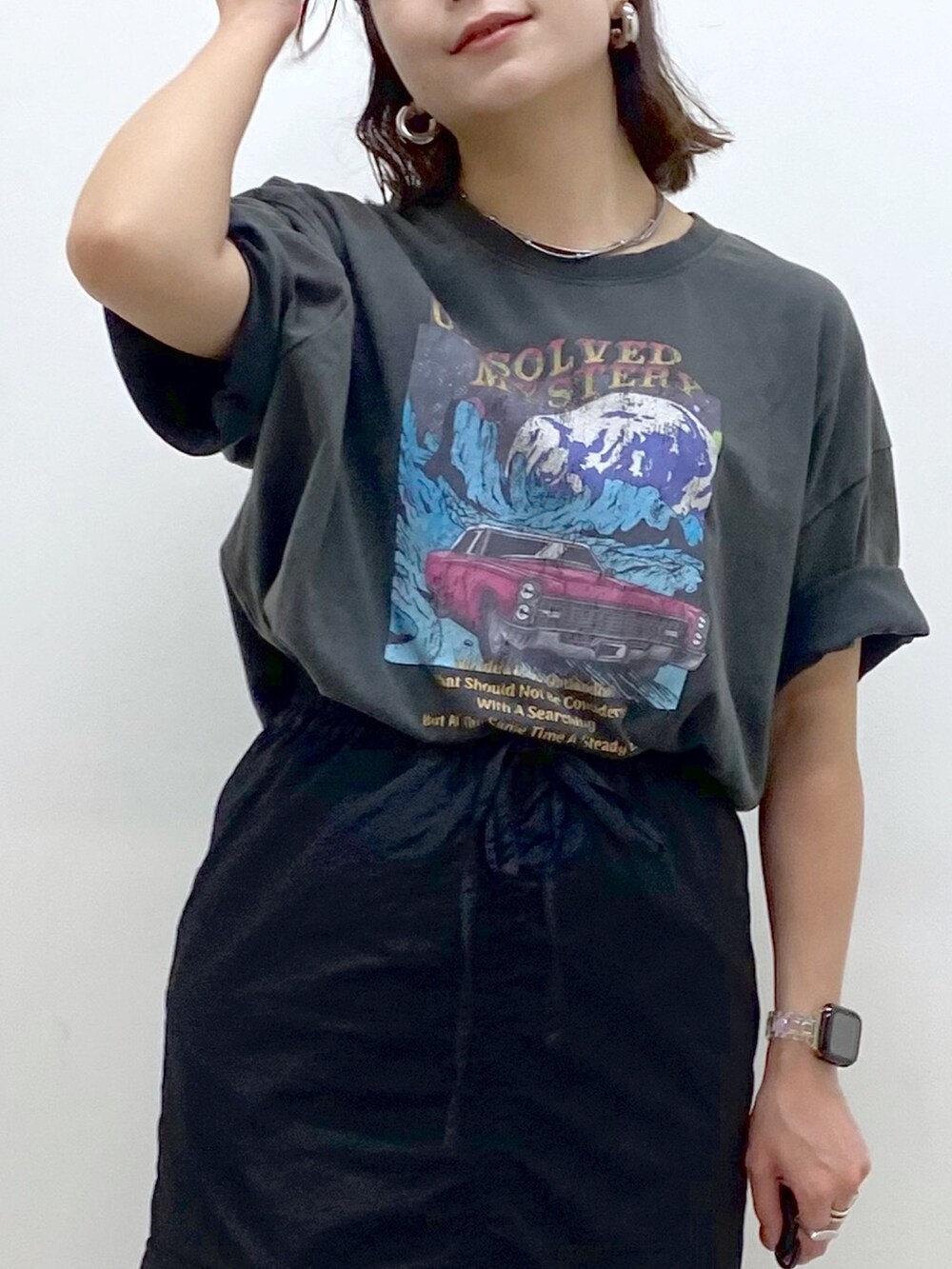 グレー系のTシャツ/カットソー、ブラック系のスカート、ブラック系のスニーカーを着用したレディースの夏コーディネートの2枚目の写真