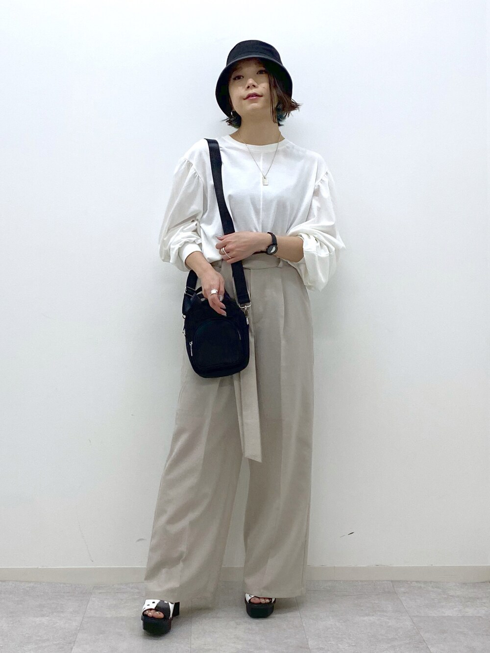 ホワイト系のTシャツ/カットソー、ベージュ系のその他パンツ、ブラック系のショルダーバッグを着用したレディースの春コーディネートの2枚目の写真