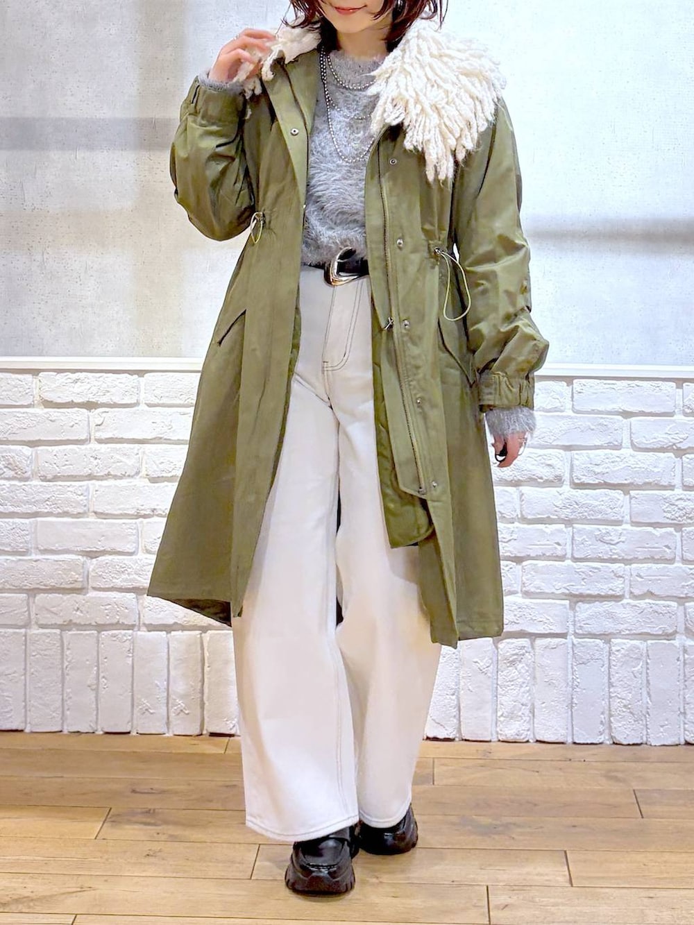 ベージュ系のボストンバッグ、グリーン系のモッズコート、ブラック系のローファーを着用したレディースの冬コーディネートの2枚目の写真